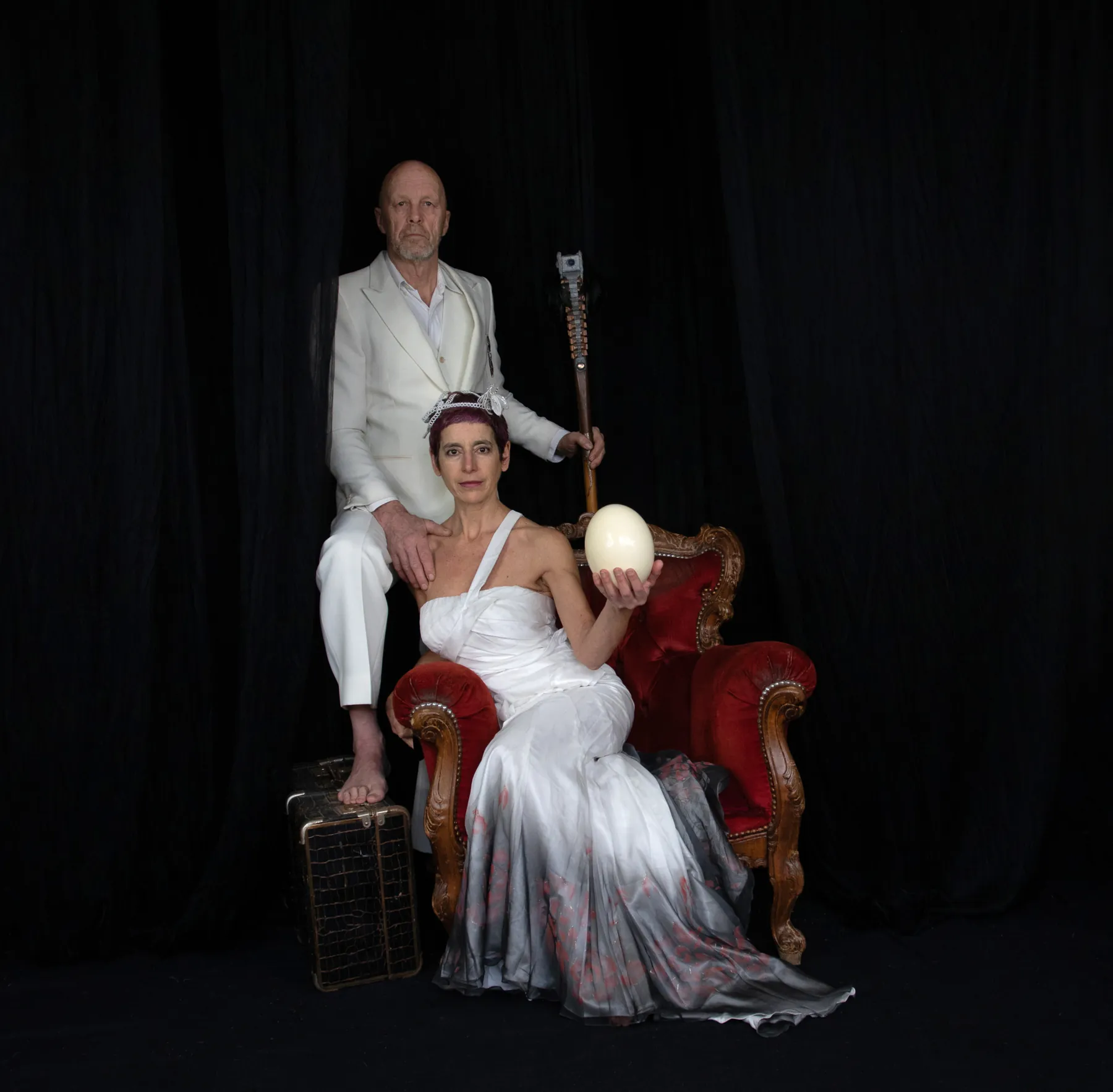 Autoportrait avec Henk Slomp : un homme en blanc assis dans un fauteuil rouge, une femme en robe blanche à ses pieds